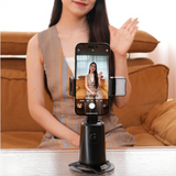 A woman using the A200 Intelligent Face Tracking Phone Stand in black, showing AI-powered 360º rotation, gesture control, warm LED light, and built-in selfie stick for hands-free video recording.
