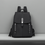 Black anti-theft buckle backpack on a gray surface with a gray background