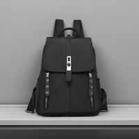 Black anti-theft buckle backpack on a gray surface with a gray background