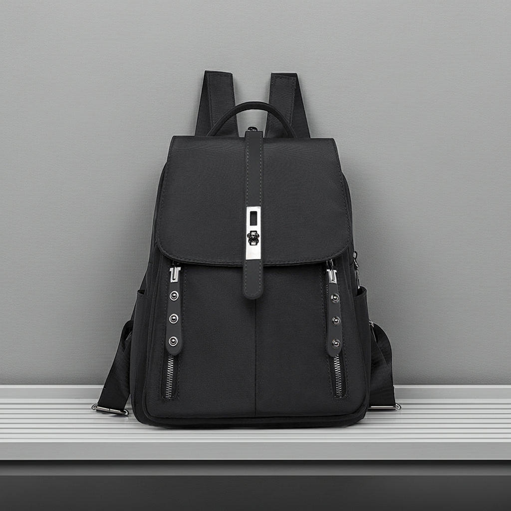 Black anti-theft buckle backpack on a gray surface with a gray background