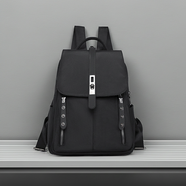 Black anti-theft buckle backpack on a gray surface with a gray background