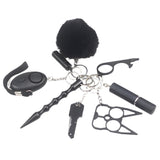 8-piece women’s self-defense keychain set in silver, including alarm, self-defense stick, window breaker, whistle, knife, knuckle tool, bottle holder, and pompom—all arranged neatly for display.