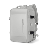 Expandable travel backpack in light gray, water-resistant with multiple compartments, feminine style, TSA zipper access, laptop pocket, shoe and wet item sections, and USB charging port. 