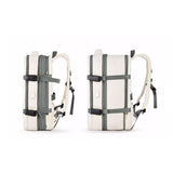 Extendable travel backpack in beige with green details, water-resistant with multiple compartments, TSA zipper access, laptop pocket, shoe and wet item sections, and USB charging port. Side view of expansion.