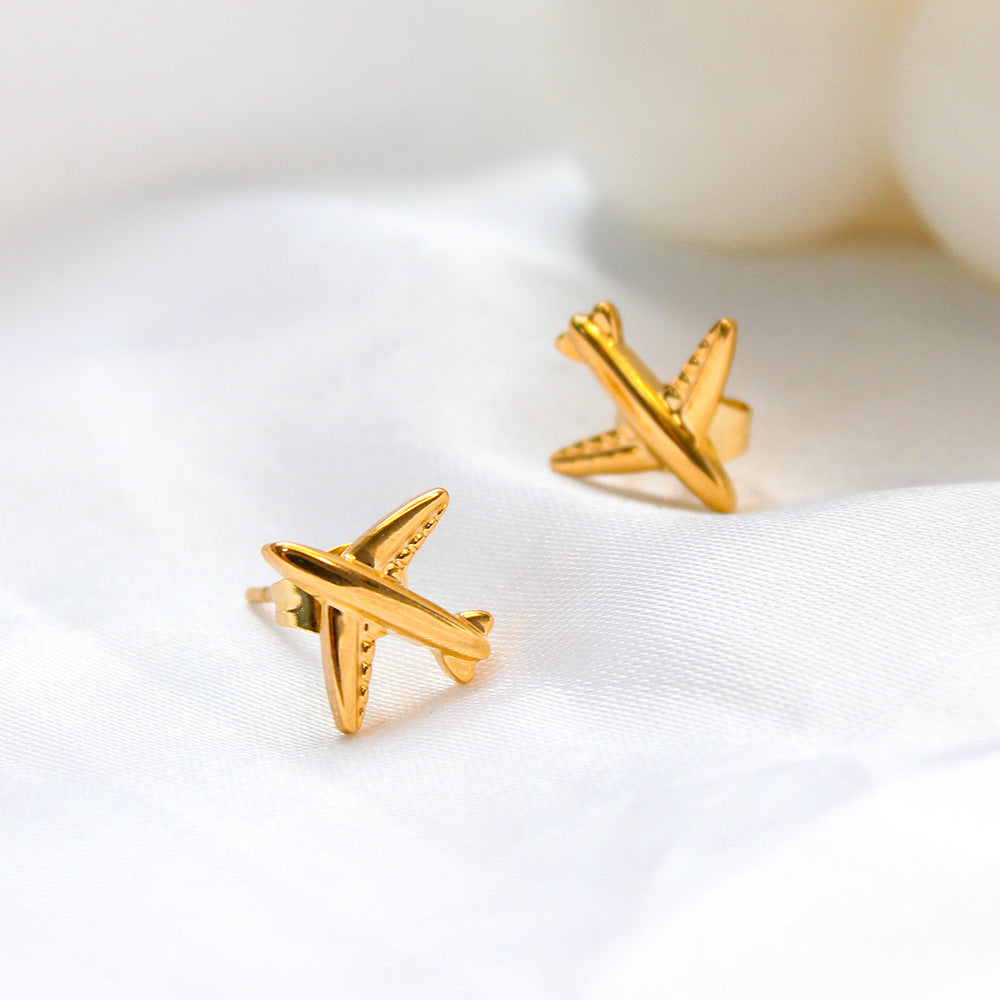 Gold airplane stud earrings made of titanium steel, hypoallergenic and lightweight, travel-inspired minimalist design for women.