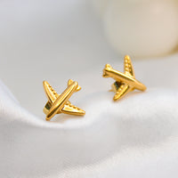 Gold airplane stud earrings made of titanium steel, hypoallergenic and lightweight, travel-inspired minimalist design for women.