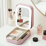 Pink makeup organizer with mirror on a white surface with cosmetic items.