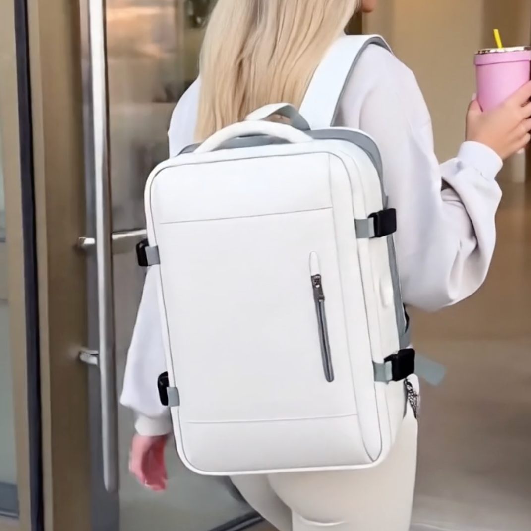 Stylish woman wearing a cute aesthetic beige expandable travel backpack with laptop compartments entering a building