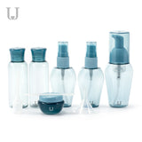 A set of refillable cosmetic containers in blue and clear colors, including various sizes with pump and spray nozzles, intended for travel use. .