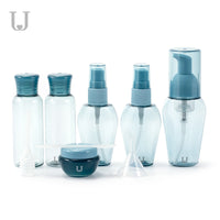 A set of refillable cosmetic containers in blue and clear colors, including various sizes with pump and spray nozzles, intended for travel use. .