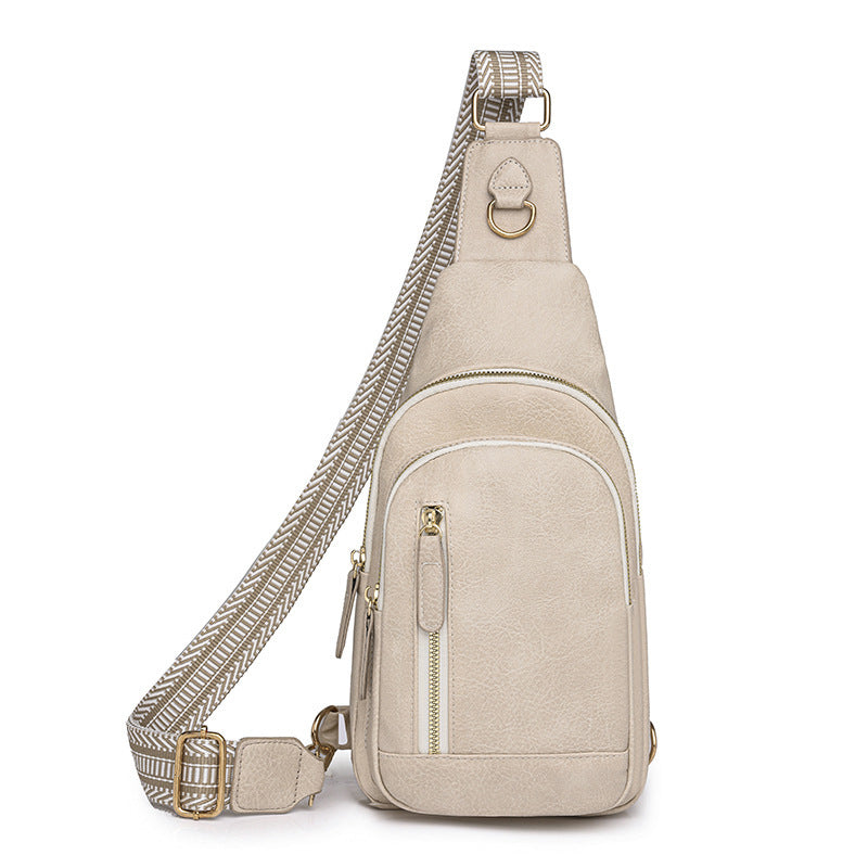 A beige chic retro cross body bag with a textured strap and multiple compartments.