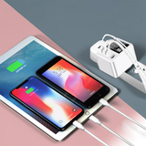 Multiple electronic devices, including smartphones and a tablet, connected to a charging station with multiple outlets.