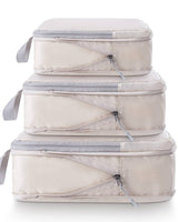 Set of three beige packing cubes with clear zipper sections on a white background