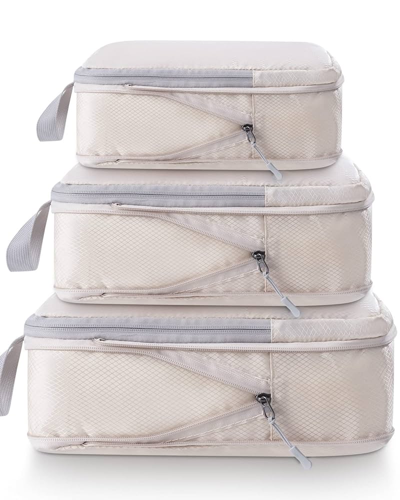 Set of three beige packing cubes with clear zipper sections on a white background