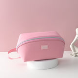 A pink travel underwear organizer bag made from Oxford cloth, displayed against a pink background.