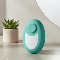 Crystal smooth skin hair remover with nano-glass surface in teal, compact handheld hair removal tool with ergonomic finger ring, shown in a clean minimalist setting.