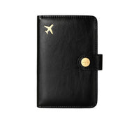 Black leather travel passport valuables organizer with gold airplane emblem and button on a white background