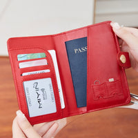 Woman holding a red travel wallet passport cover with airplane emblem held by a hand against a neutral background
