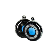 A wireless candid camera detector with a compact, circular design featuring a blue indicator dial and black exterior.