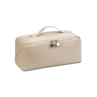 A cosmetics pillow organizer in a beige color with a zipper closure and a decorative star charm.