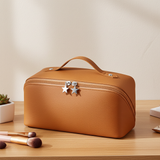 Brown cosmetic bag with star-shaped zippers on a wooden surface