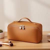 Brown cosmetic bag with star-shaped zippers on a wooden surface