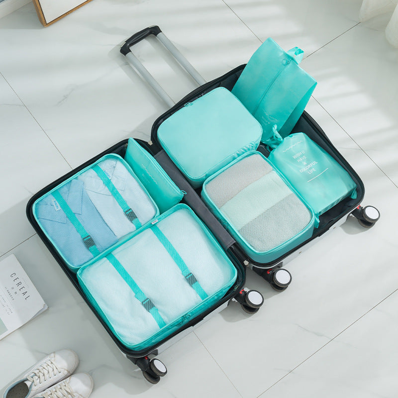 Open suitcase with turquoise blue packing cube organizers  on a tiled floor