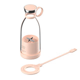 A portable smoothie maker with a pink base and a clear bottle attachment, along with a magnetic charging cable.