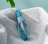 A set of refillable cosmetic containers in blue and clear colors, including various sizes with pump and spray nozzles, intended for travel use.