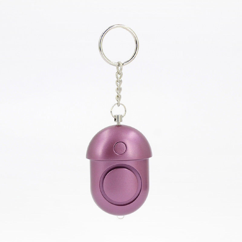 Compact 130dB personal alarm attached to keychain, travel-friendly safety device for women.
