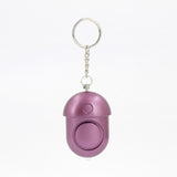 Compact 130dB personal alarm attached to keychain, travel-friendly safety device for women.