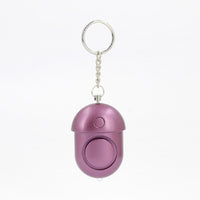 Compact 130dB personal alarm attached to keychain, travel-friendly safety device for women.
