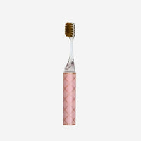 Pink toothbrush with a textured handle on a white background
